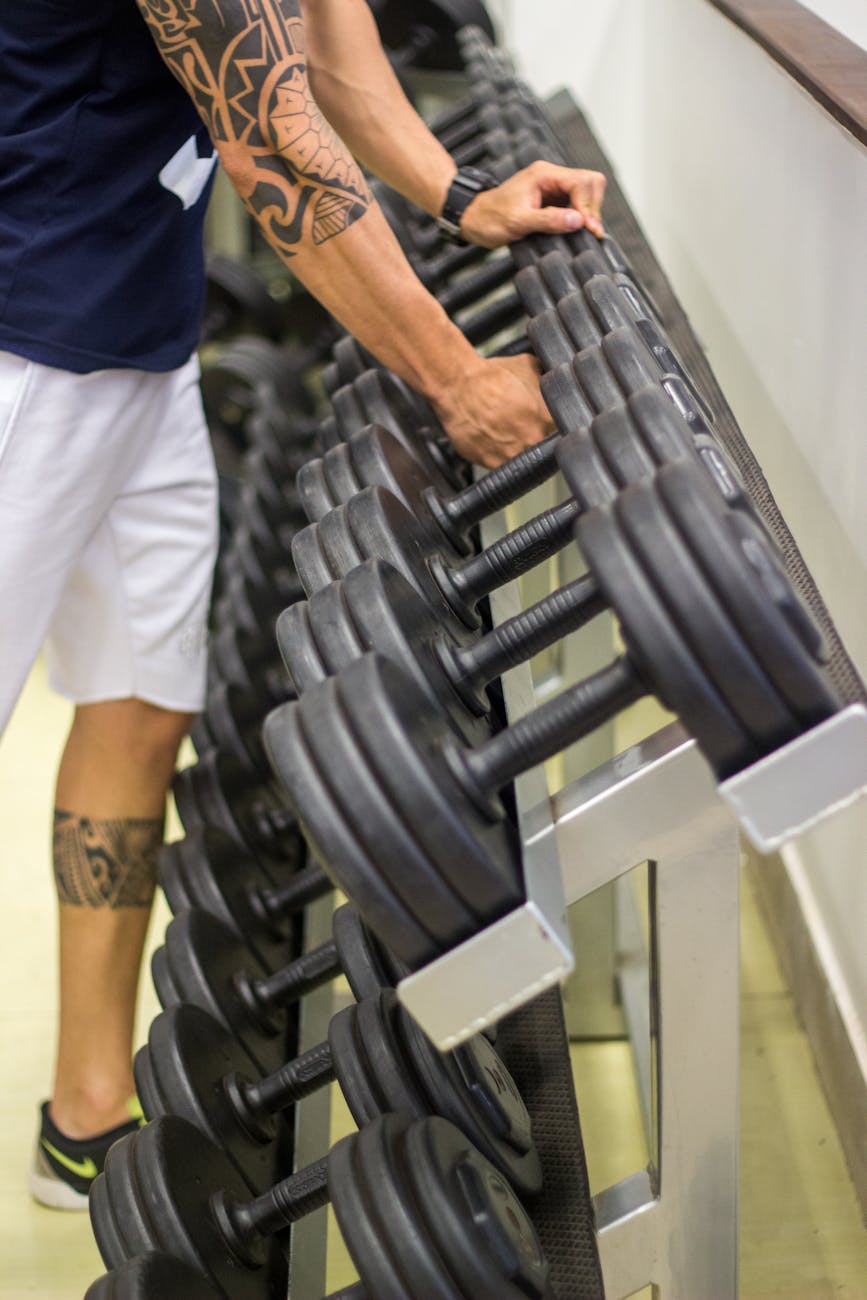 a person in blue shirt holding black dumbbells